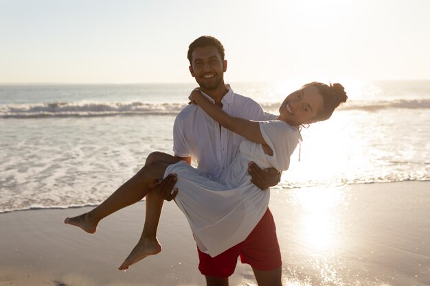 Homem, mulher levando, em, seu, braços, praia