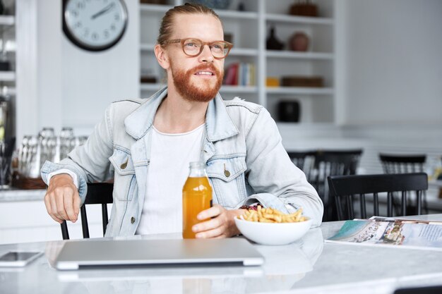 Homem na moda hippie vestido com uma camisa jeans e óculos elegantes