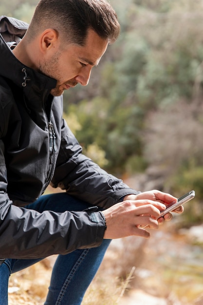 Foto grátis homem na natureza usando celular