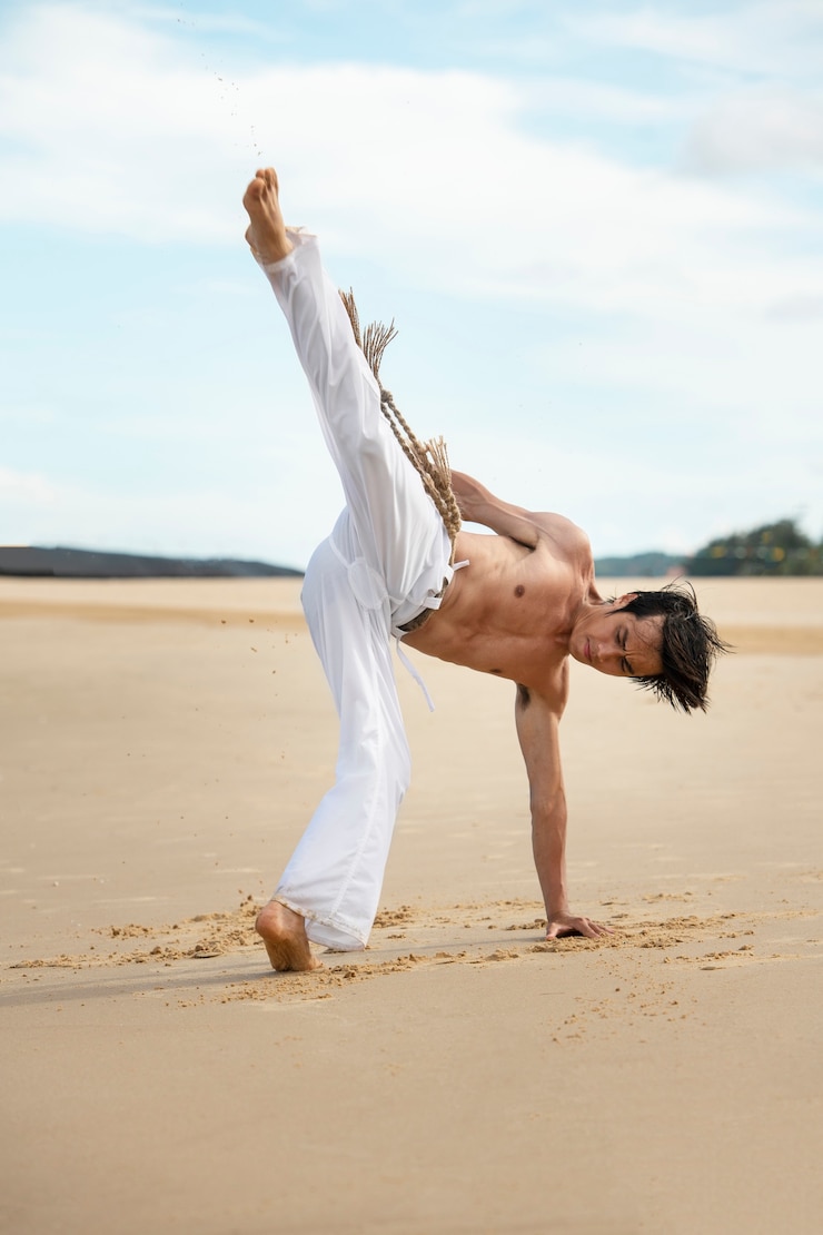 Foto grátis homem na praia praticando capoeira sozinho
