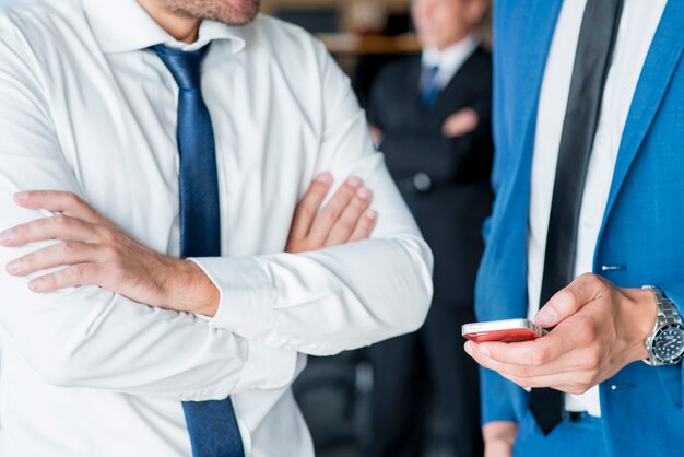 Homem negócios, com, seu, colega, segurando, cellphone