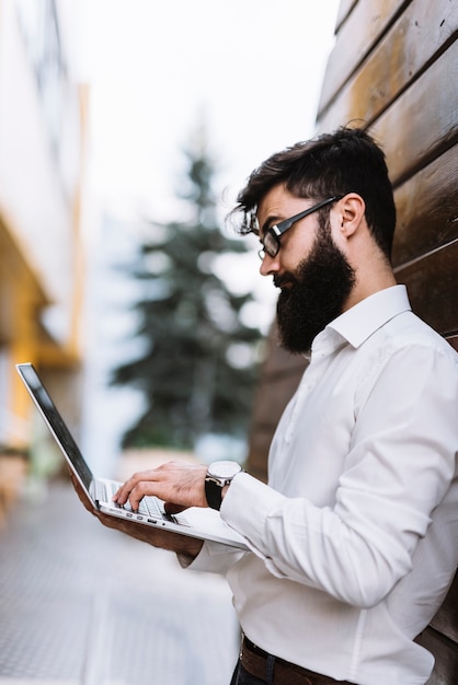 Homem negócios, em, camisa branca, digitando, ligado, laptop