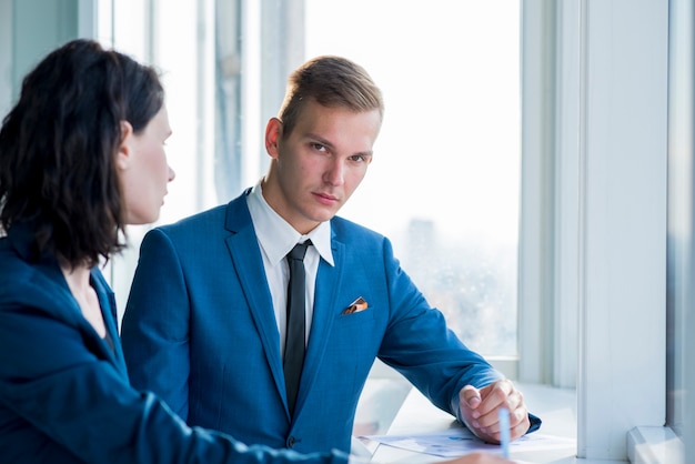 Homem negócios, sentando, com, seu, colega feminino, em, escritório