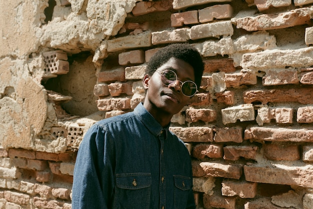 Homem negro de tiro médio posando com óculos de sol