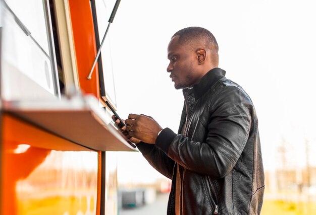 Homem negro no meio do tiro fazendo pedido no food truck