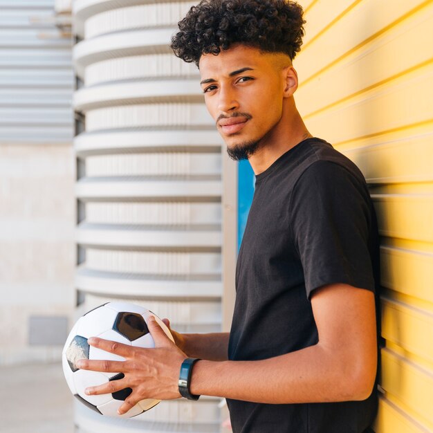 Homem negro, segurando bola, e, olhando câmera