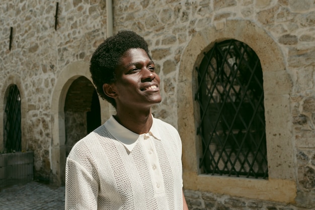 Homem negro sorridente de tiro médio posando