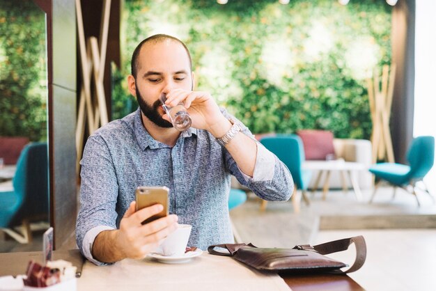 Homem no café relaxando com o telefone