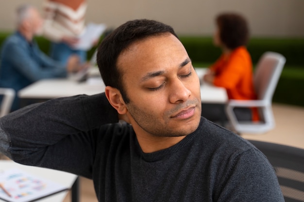 Homem no escritório se alongando durante um dia de trabalho