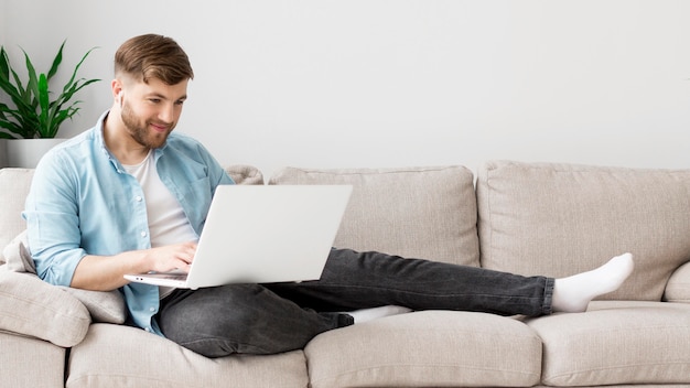 Homem no sofá com o laptop