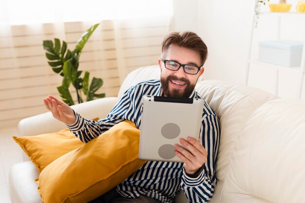 Homem no sofá em casa com tablet