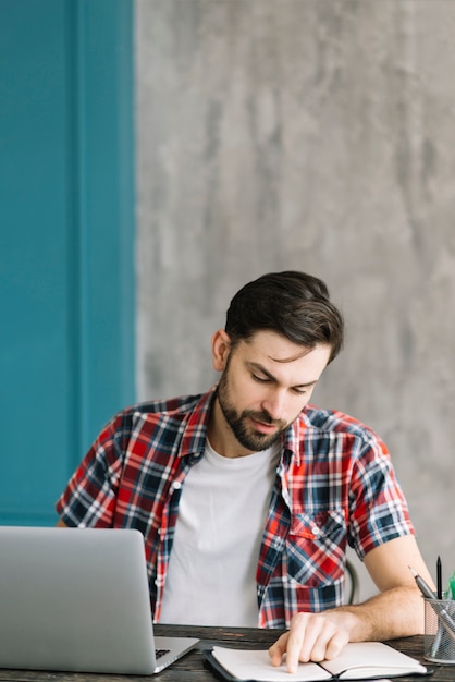 Homem, notas leitura, perto, laptop