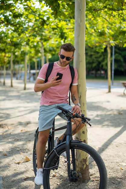 Homem novo dos esportes em uma bicicleta em uma cidade européia. Esportes em ambientes urbanos.