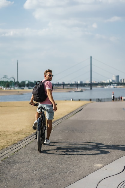 Foto grátis homem novo dos esportes em uma bicicleta em uma cidade européia. esportes em ambientes urbanos.