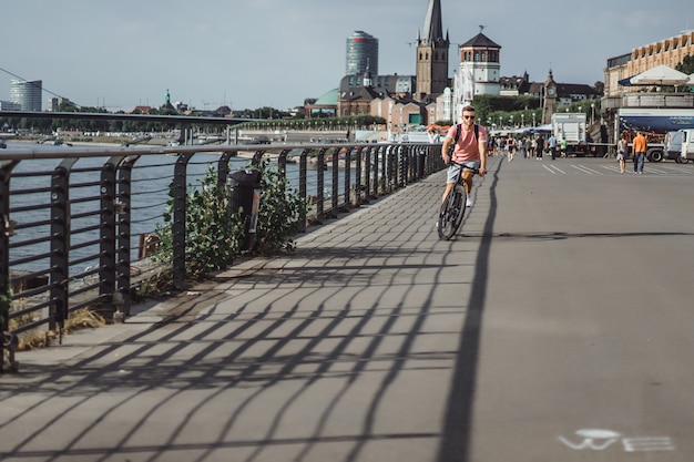 Homem novo dos esportes em uma bicicleta em uma cidade européia. Esportes em ambientes urbanos.