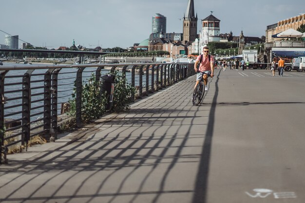 Homem novo dos esportes em uma bicicleta em uma cidade européia. Esportes em ambientes urbanos.