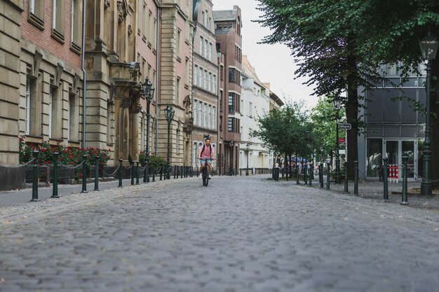 Homem novo dos esportes em uma bicicleta em uma cidade européia. Esportes em ambientes urbanos.