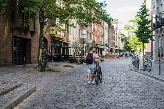 Homem novo dos esportes em uma bicicleta em uma cidade européia. Esportes em ambientes urbanos.