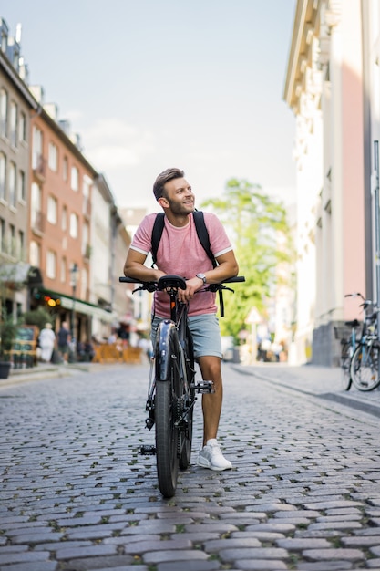 Homem novo dos esportes em uma bicicleta em uma cidade européia. esportes em ambientes urbanos.