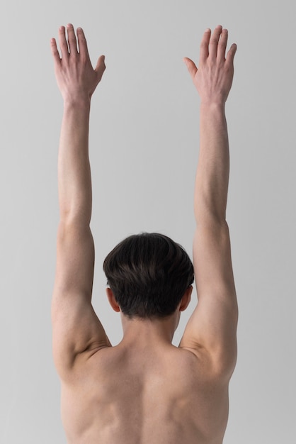Foto grátis homem nu de costas com os braços levantados