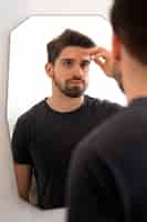 Foto grátis homem olhando na vista lateral do espelho