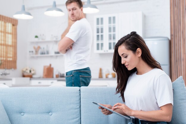 Homem olhando para a namorada que está olhando para o tablet