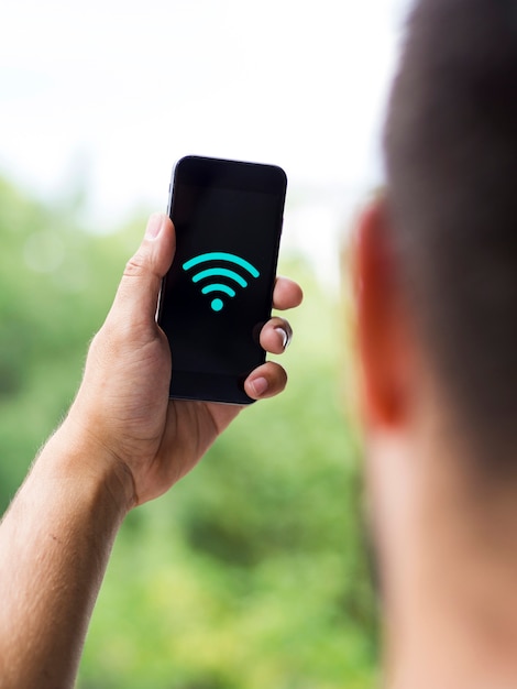 Homem olhando para a tela do telefone com o símbolo wifi