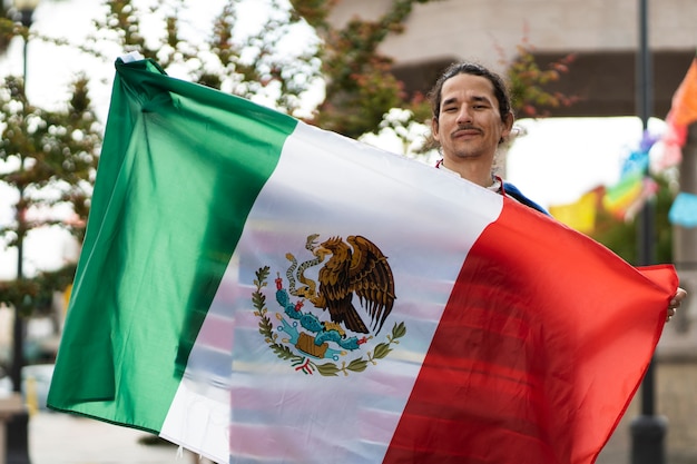 Homem orgulhoso de vista frontal segurando a bandeira mexicana