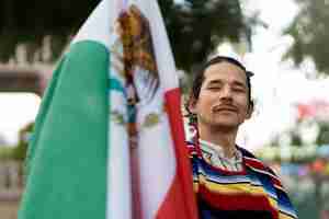 Foto grátis homem orgulhoso segurando a bandeira mexicana tiro médio