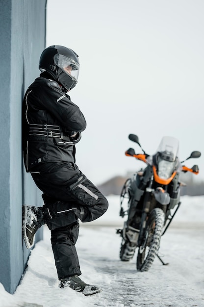 Homem parado ao lado da motocicleta com capacete
