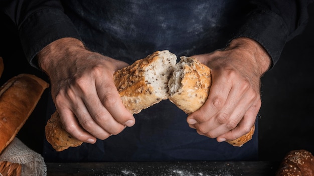 Homem partindo um pão