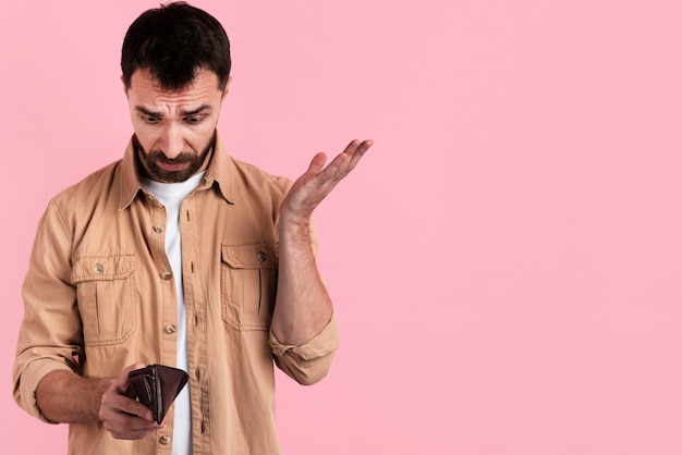 Foto grátis homem perplexo olhando para smartphone