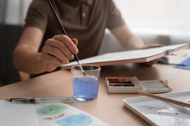 Homem pintando com aquarelas