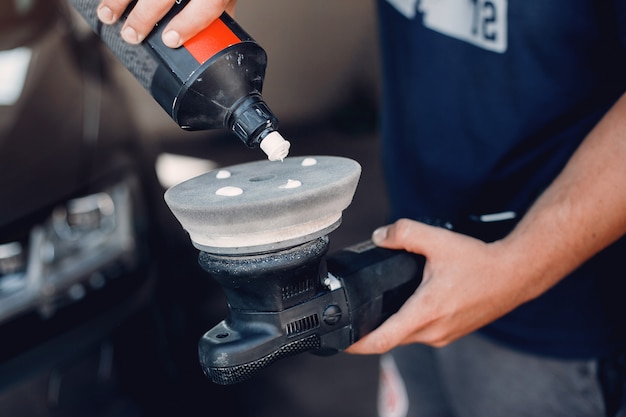 Homem polir um carro em uma garagem