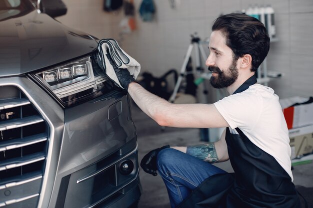 Homem polir um carro em uma garagem