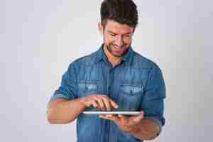 Foto grátis homem posando com camisa jeans e tablet