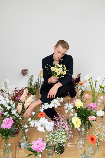 Homem posando com flores de alto ângulo