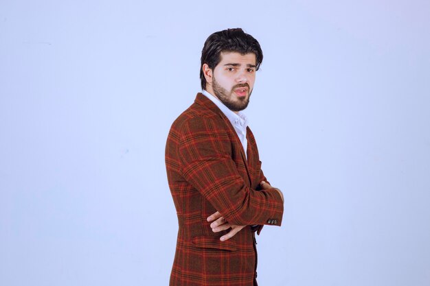 Homem posando com um blazer marrom da moda