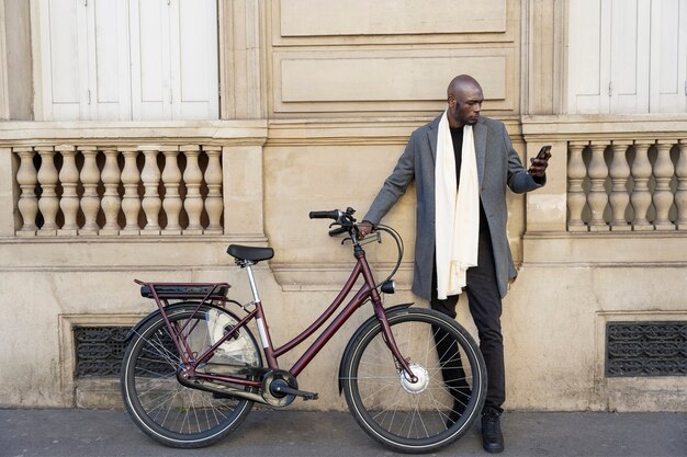 Homem posando com uma bicicleta na cidade na frança