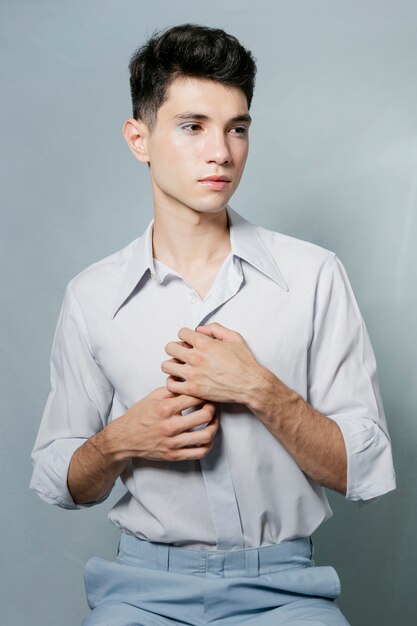 Homem posando e segurando a camisa