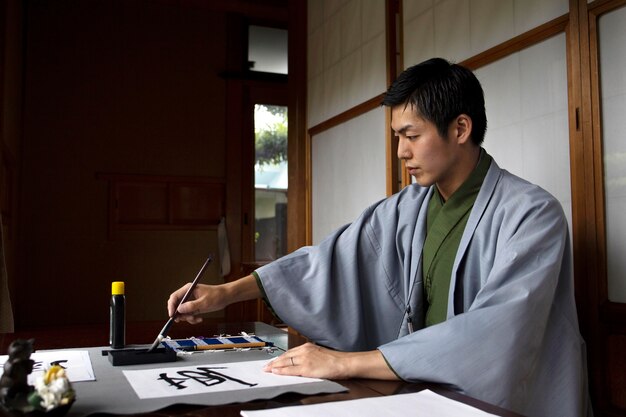 Homem praticando caligrafia japonesa com um pincel