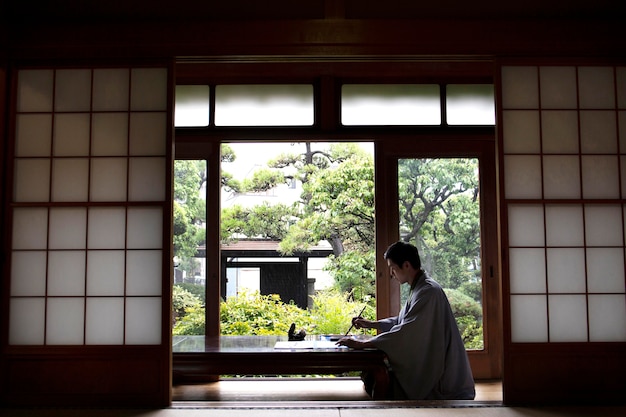 Foto grátis homem praticando caligrafia japonesa com um pincel