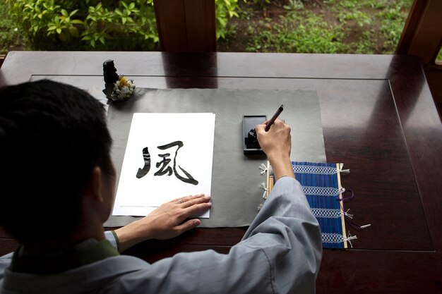 Homem praticando caligrafia japonesa