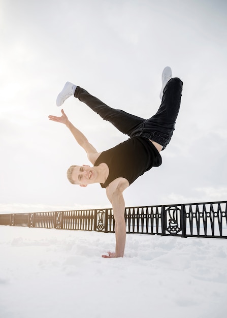 Homem praticando hip hop fora na neve