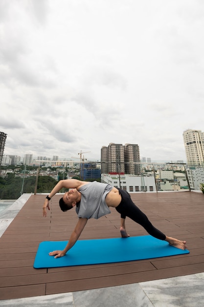 Homem praticando posição de ioga com espaço de cópia