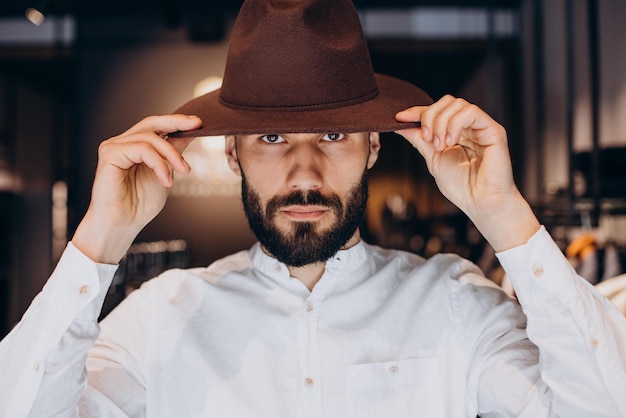 Foto grátis homem procurando chapéu na loja masculina