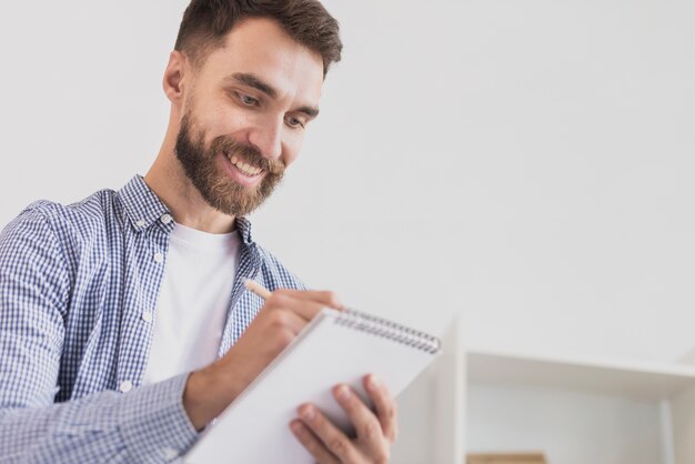 Foto grátis homem produtivo, escrevendo no bloco de notas