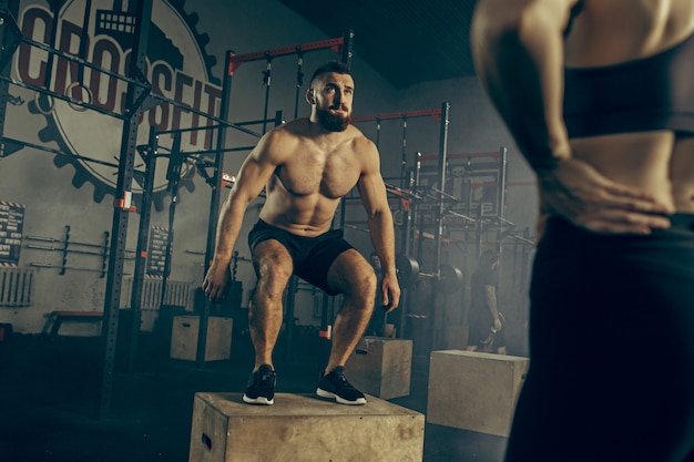 Foto grátis homem pulando durante exercícios no ginásio de fitness. crossfit.