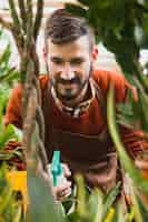 Foto grátis homem pulverizando flores