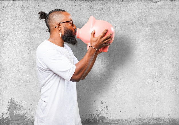 Foto grátis homem que beija um banco piggy